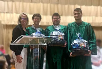 photo of Merideth Wohl presenting scholarship to recipients